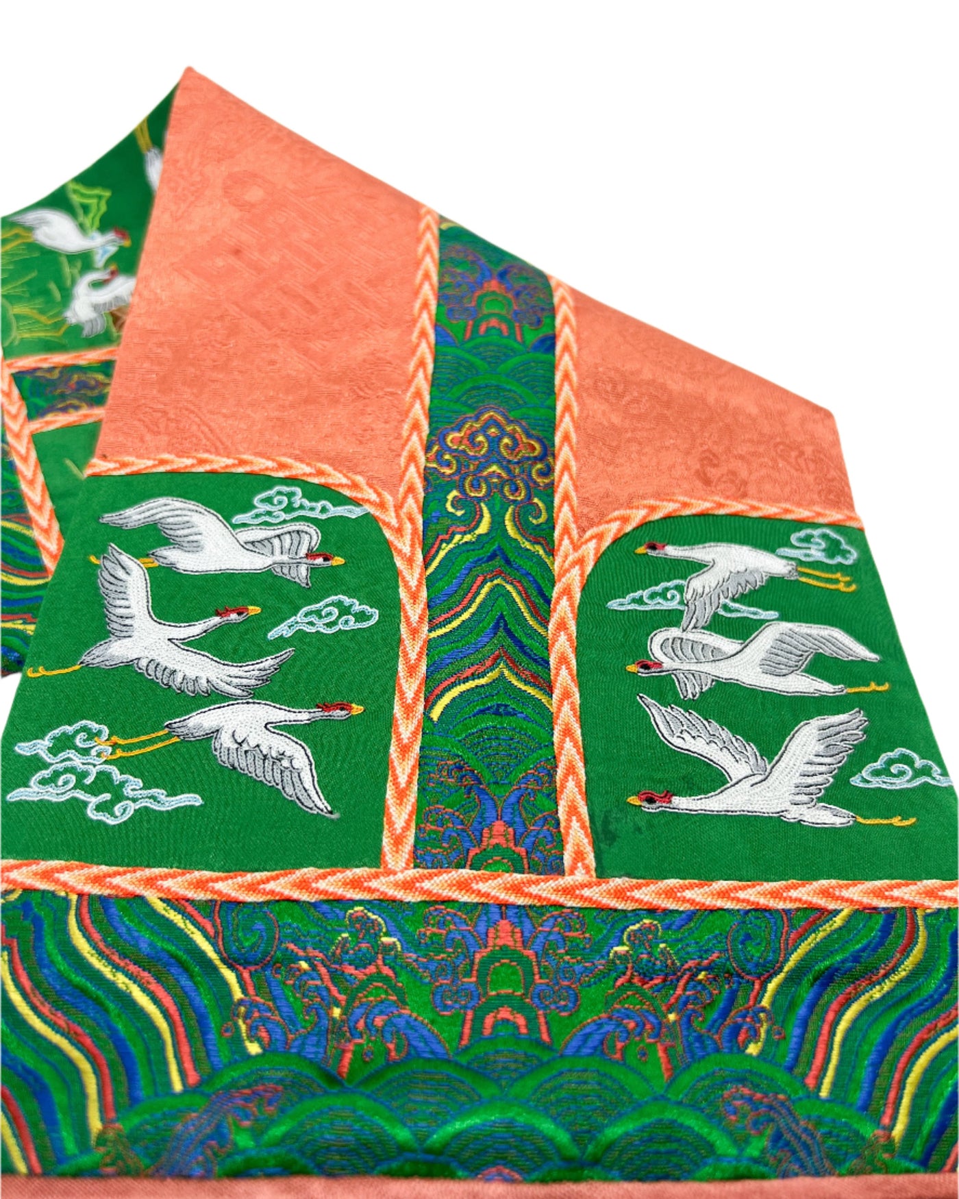 The Crane is intricately embroidered. The design is finished with fishbone stitching and decorated with a coin braid stitchon a orange and green silk base. 