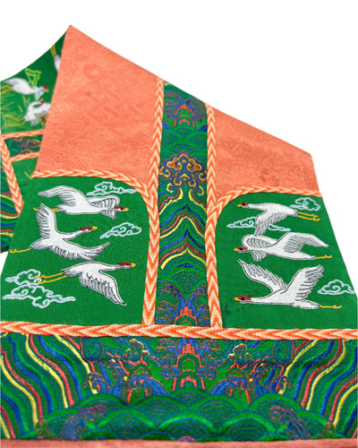 The Crane is intricately embroidered. The design is finished with fishbone stitching and decorated with a coin braid stitchon a orange and green silk base. 