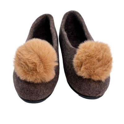 Top-down view of felt loafers with yellowish beige pom pom, made in Mongolia, displayed on a white background.